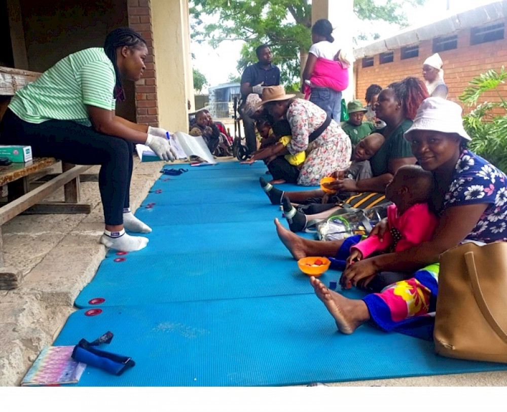 Das Bild zeigt eine Gruppe sitzender Frauen bei einem Workshop der Arche Simbabwe.