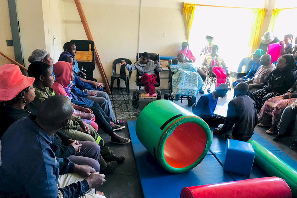 Bild zeigt eine Gruppe Menschen in Simbabwe bei der Ergotherapie.