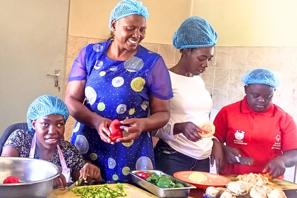 Bild zeigt eine Gruppe Menschen in Simbabwe beim Kochen.